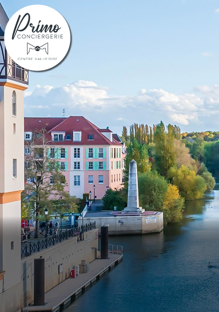 Bâtiments colorés et rivière dans le Centre Val-d'Oise, par une journée ensoleillée.