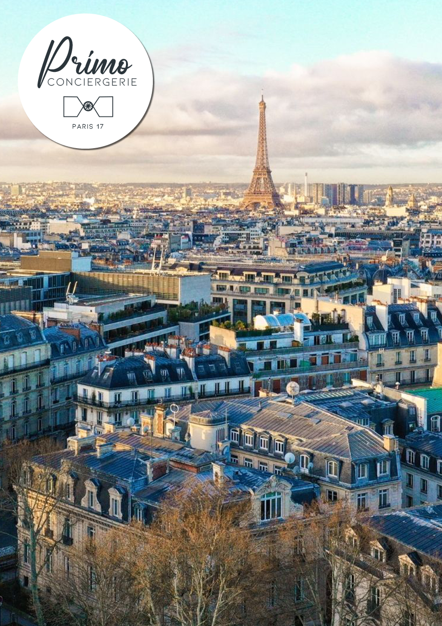 Vue aérienne sur les toits de Paris avec la Tour Eiffel au loin.