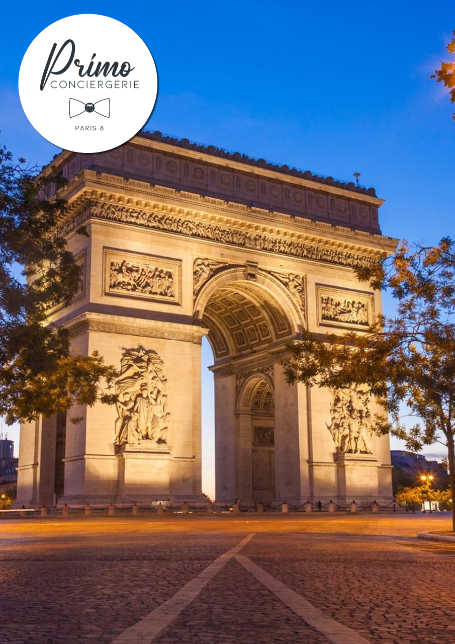 L'Arc de Triomphe illuminé au crépuscule sur les Champs-Élysées à Paris.