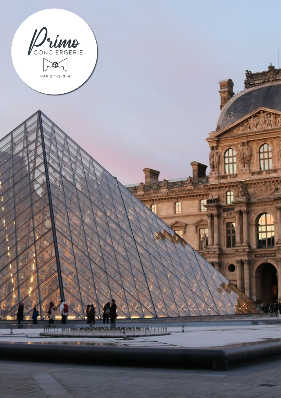 Vue de la pyramide du Louvre et de la façade historique du musée au crépuscule.