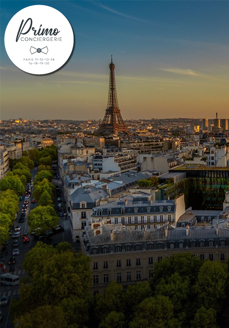 Vue de la tour Eiffel depuis le 16e arrondissement de Paris, avec des bâtiments haussmanniens au coucher du soleil.