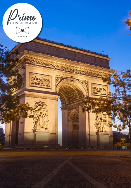 L'Arc de Triomphe illuminé au crépuscule sur les Champs-Élysées à Paris.