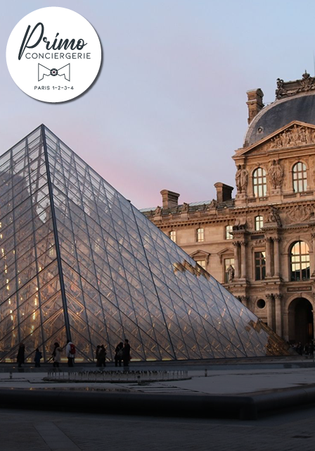 Vue de la pyramide du Louvre et de la façade historique du musée au crépuscule.